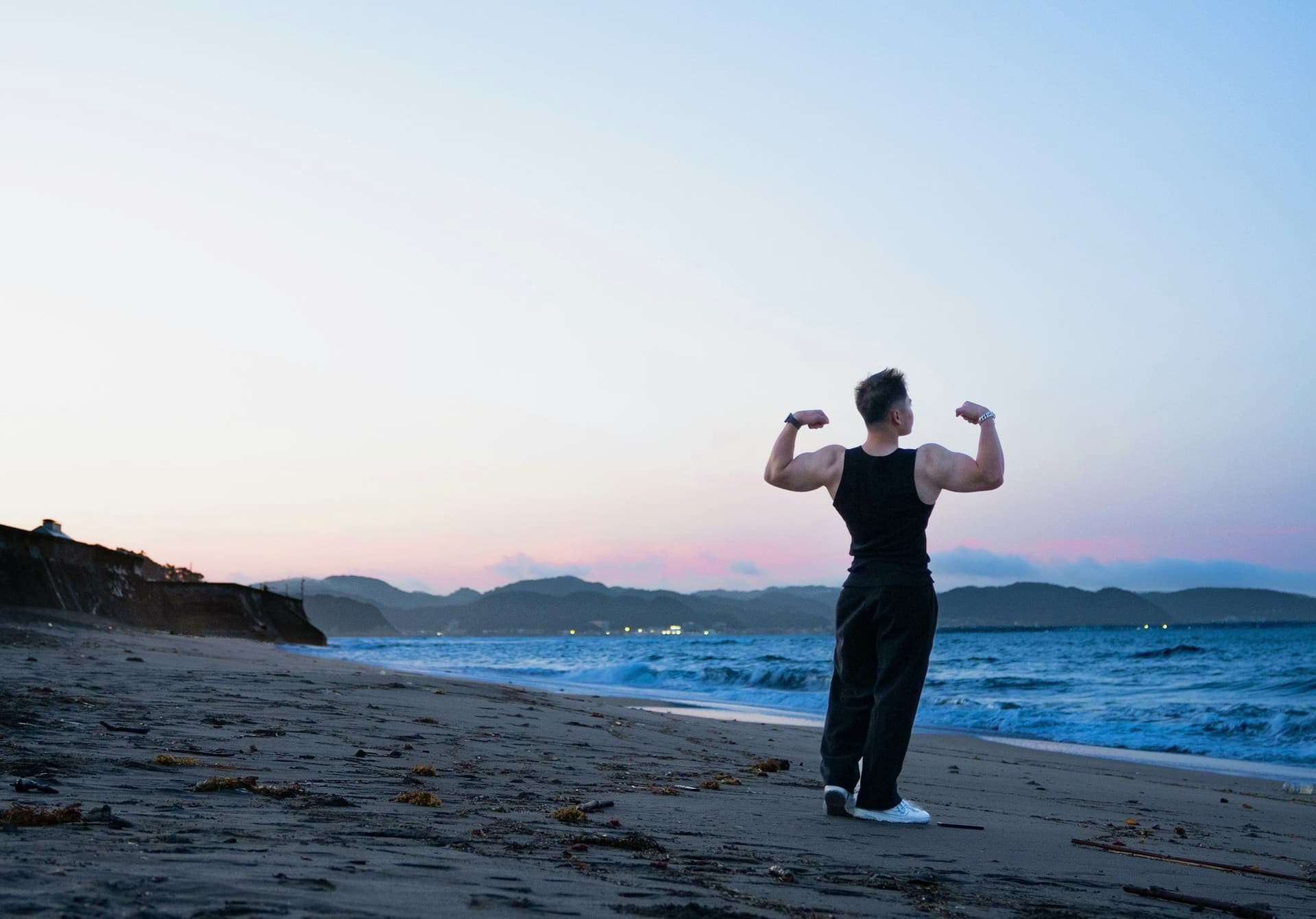 An athlete standing on the beach at dusk